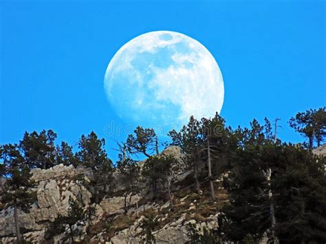A Full Moon Over The Rocky Alpine Peak Of Musflue In The Swiss Mountain