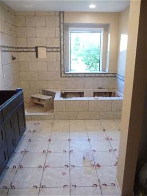 Not only have the same patterned green tiles been used on the walls and floors of this bathroom, they've also been used on the ceiling! Bathroom Remodel in Lynnwood