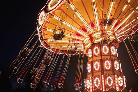 premium photo illuminated swing chain carousel in amusement park at the night