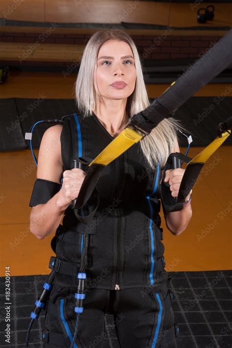 Blonde Girl In Electrical Muscular Stimulation Suit Doing Squat