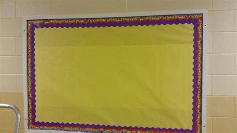 A Bulletin Board In A Classroom With Yellow Paper And Colorful Border