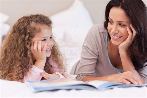 Mother Reading A Bedtime Story For Her Daughter Stock Photo Image Of