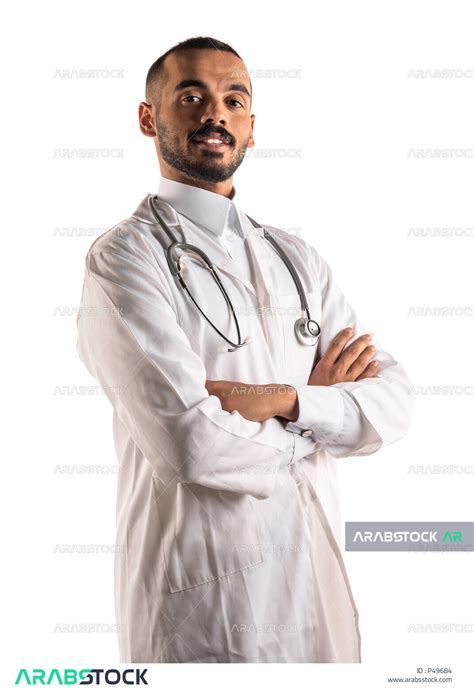 بورتريه لطبيب عربي خليجي سعودي مكتف يديه ،يرتدي المعطف الطبي و السماعة الطبية ، الوقوف بثقة