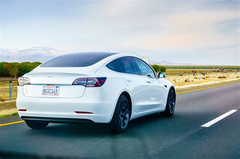 Start your 1 week free trial! White Tesla Model 3 Driving On The Freeway Stock Photo - Download Image Now - iStock