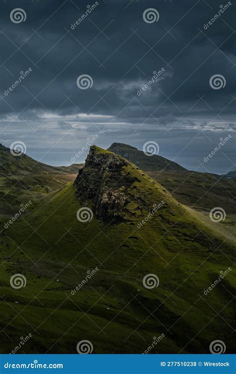 Lush Grassy Mountains Framed Against Dark Stormy Clouds Creating A