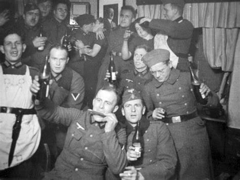 german wehrmacht and luftwaffe soldiers drinking and kissing women during a break from battle