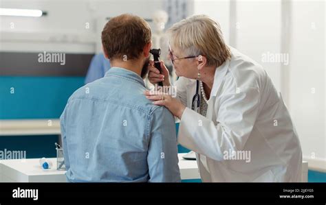 Female Otolaryngologist Consulting Patient In Medical Cabinet Doing