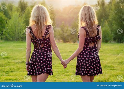 twee lesbiennes zusters tweeten mooie krulde blonde jonge vrouw in een stijlvolle jurk die