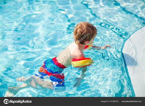 Счастливый маленький мальчик веселится в бассейне Активный счастливый