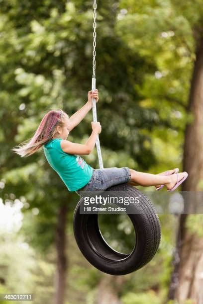 Girl Sitting On A Tire Swing Photos And Premium High Res Pictures