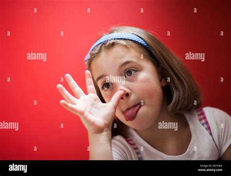 A Young Girl Pulling A Funny Face And Sticking Her Tongue Out Stock