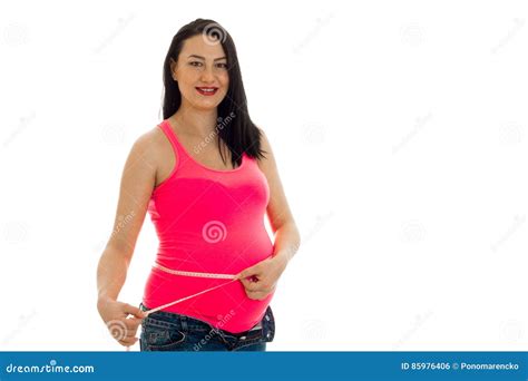 Attractive Pregnant Brunette Woman With Big Belly Posing With Measure Tape In Pink Shirt