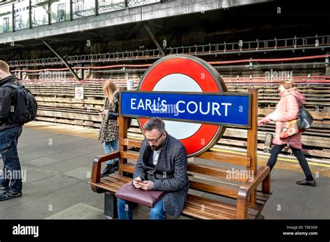 A Man Sitting On A Bench At Earls Court Underground Station London Uk