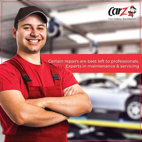 a man with his arms crossed standing in front of a car repair shop and