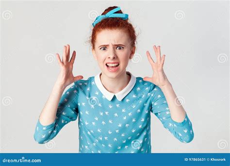 Portrait Of Young Angry Redhead Girl In Blue Dress Looking Panic