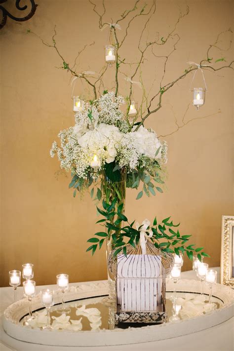 tall white flower and branch centerpiece with hanging candles branch centerpieces wedding