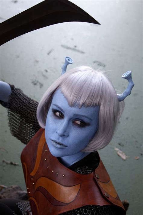 A Woman With White Hair And Blue Skin Is Holding A Large Knife In Her Hand