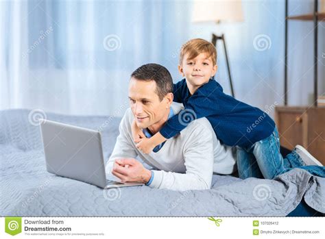 Loving Father Hugging His Son Lying On The Bed Stock Image