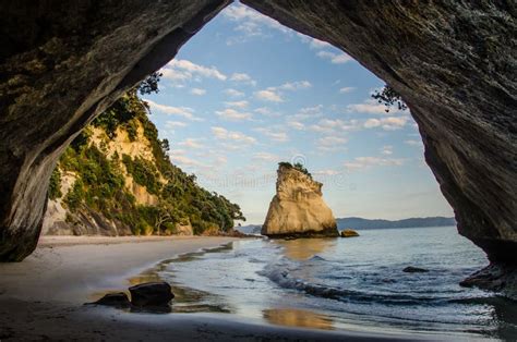Sunrise At Cathedral Cove With Blue Sky With White Clouds Above And