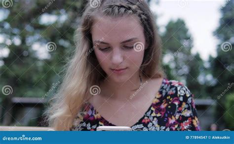 Pretty Cute Girl Using Smartphone Beside Her Bike In The Park With