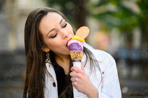 Attractive Girl Eating Ice Cream On The City Street Stock Photo