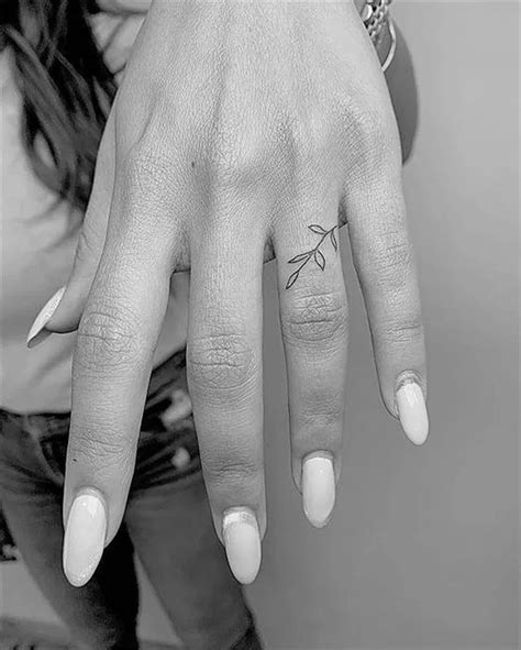 a woman s hand with a small tattoo on it