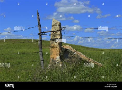 Kansas Stone Post With A Gate And Fence With Blue Sky And Clouds Stock