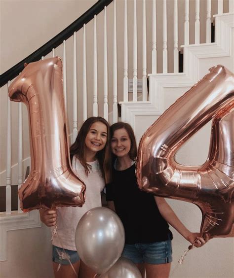 Two Women Standing Next To Each Other With Balloons In The Shape Of The Number Forty