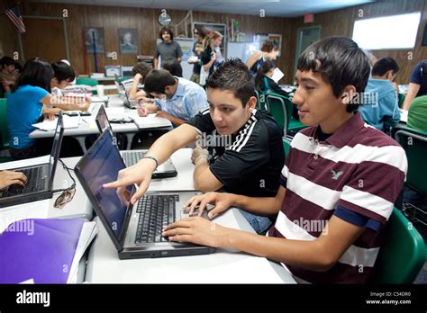 Male Hispanic Student Points To Laptop Computer Screen In Texas High