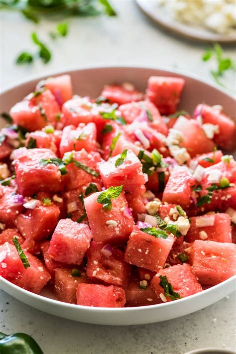 Watermelon Salad In A White Bowl With Basil On Top