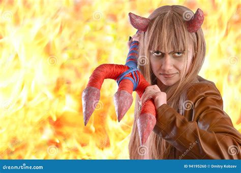 Girl In The Guise Of A Devil On The Background Of Fire Stock Photo