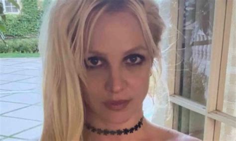 britney spears goes topless and wears nothing but a necklace as she makes funny faces in bed for