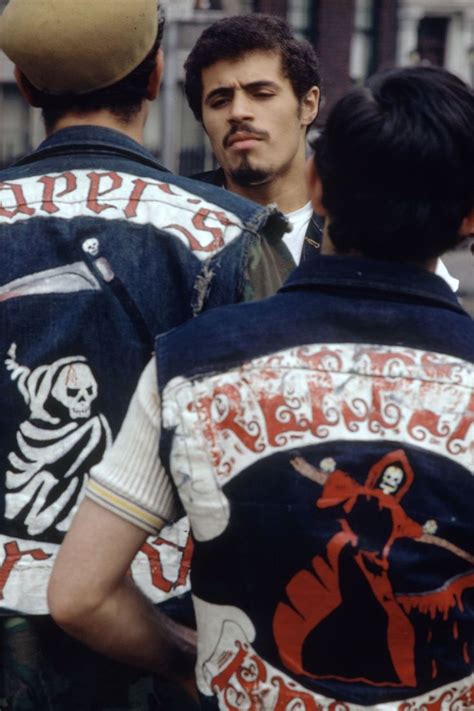 Two Men Wearing Jackets With Skulls On Them Are Talking To Each Other