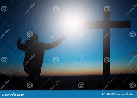 Cross Of Jesus Man Kneeling Worshiping God In Prayer Stock Photo