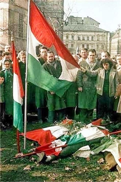 A Group Of People Standing Next To Each Other In Front Of A Flag Laying