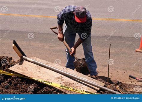 Worker With Shovel Is Digging A Pit On Construction Site Concept Of