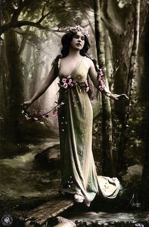 A Woman Standing In The Woods With Her Arms Outstretched And Flowers On