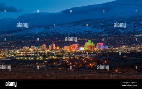 Reno Nevada Skyline At Night With Snowy Mountains In The Distance
