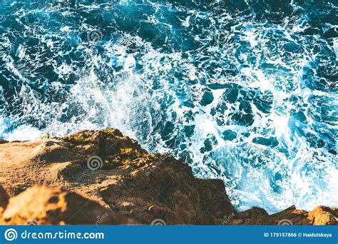 Top View Of Sea Waves Hitting Rocks On The Beach With Turquoise Blue