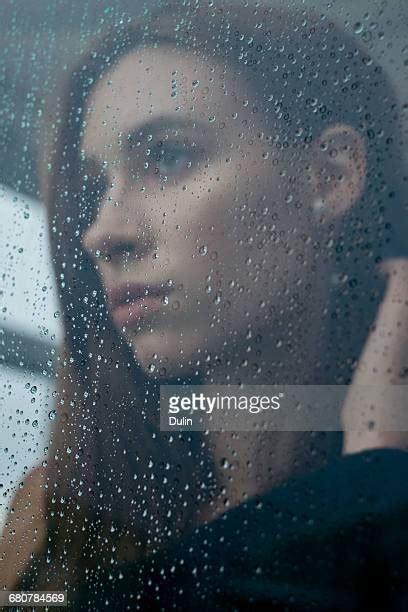 Young Woman Looking Through Window On Rainy Day Photos And Premium High