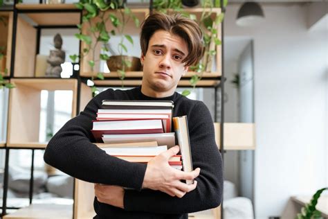 Confused caucasian student in library holding books - Sane Spaces
