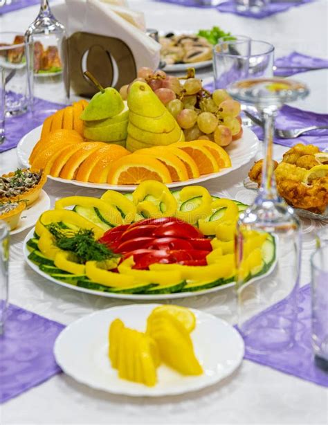 Festive Banquet Table Decorated With Plates With Vegetable And Fruit