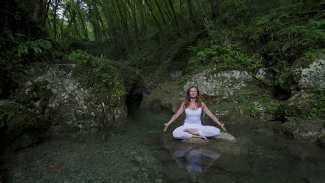 Woman Sitting In Meditation Under Waterfall In Bali Indonesia Stock