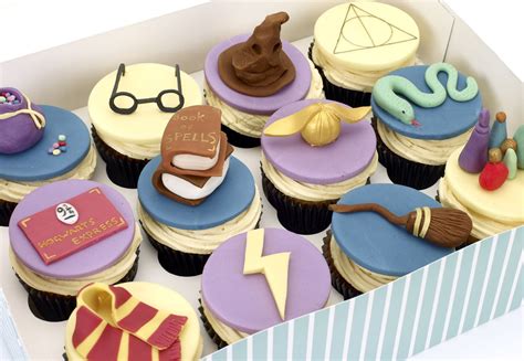 a box filled with lots of cupcakes decorated like harry potter and hogwarts