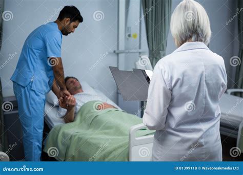 Doctor And Surgeon Consulting Patient In Ward Stock Photo Image Of