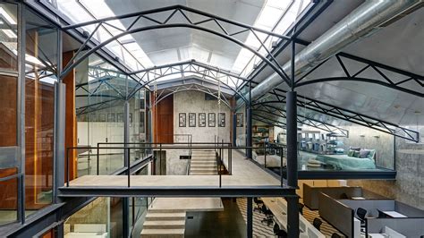 Offices In A Converted Warehouse Centre Around Suspended Concrete Stair