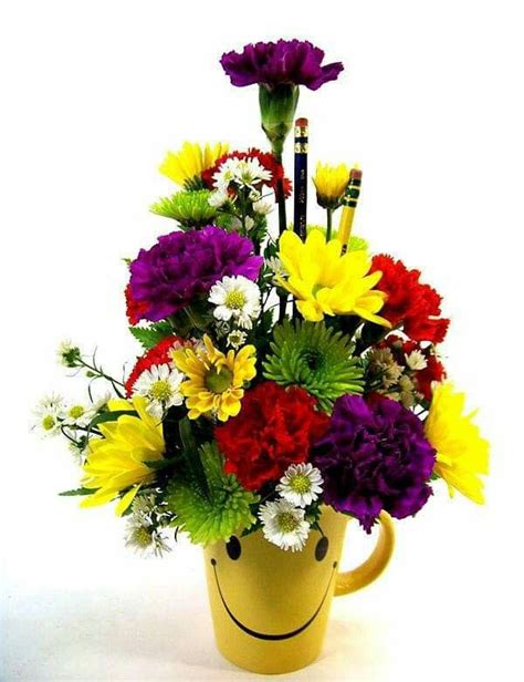 A Yellow Mug Filled With Lots Of Colorful Flowers Next To A Pencil