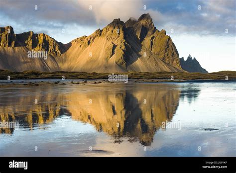 Stokksnes And Vestrahorn Mountains In Late Afternoon Light Reflected In