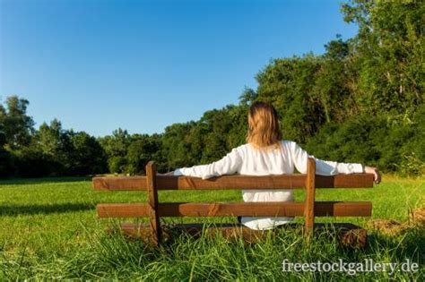 Bank in der nähe von mir. Frau sitzt auf einer Bank in der Natur