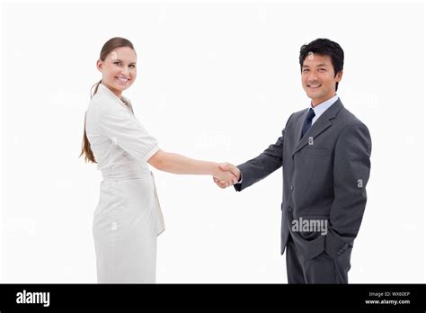 Two Business People Shaking Hands Against A White Background Stock